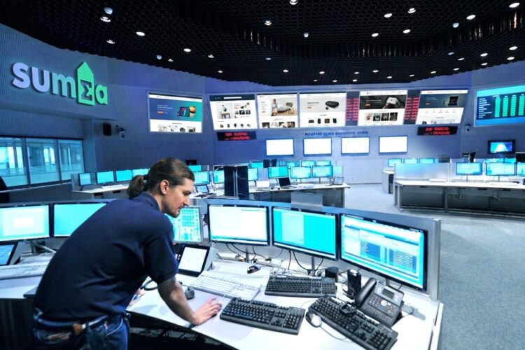 Control room with the Summa logo and webshop pages on the video wall, an operator at a console full of monitors in the foreground